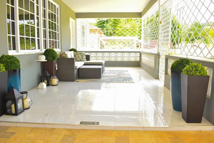Covered porch with polished tile, lanterns and planters